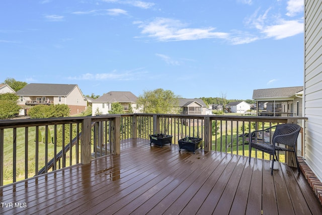 wooden terrace with a residential view and a lawn