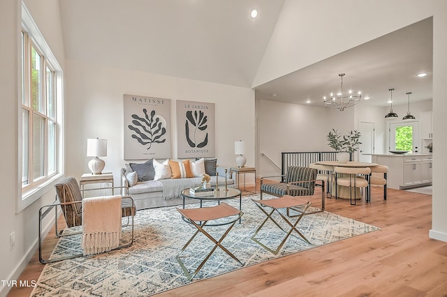living room featuring recessed lighting, wood finished floors, a chandelier, baseboards, and high vaulted ceiling