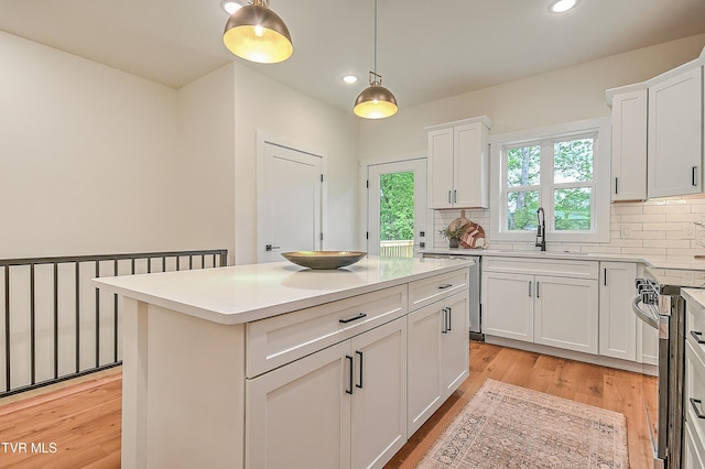 kitchen with a sink, backsplash, stainless steel appliances, recessed lighting, and white cabinets