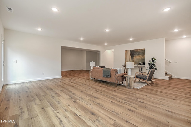 living area featuring light wood-style floors, stairway, recessed lighting, and baseboards