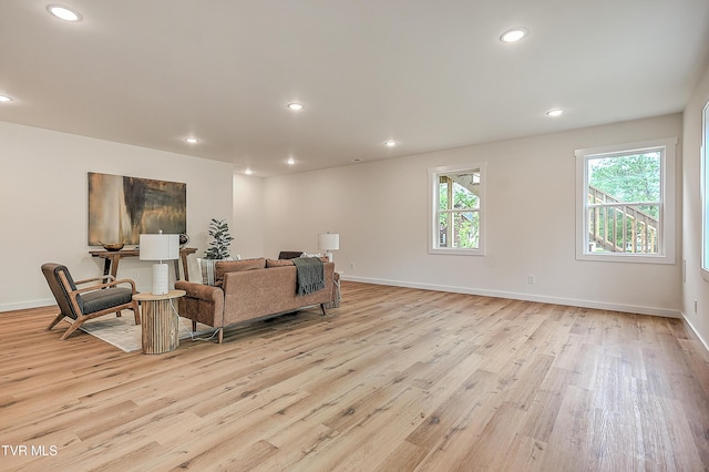 living room with light wood-type flooring, plenty of natural light, recessed lighting, and baseboards