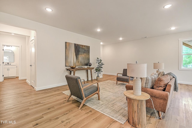 living area with light wood finished floors, baseboards, and recessed lighting