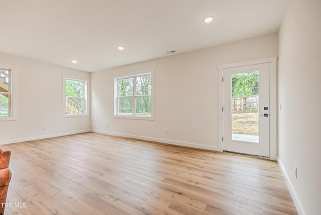 unfurnished living room featuring healthy amount of natural light, light wood finished floors, recessed lighting, and baseboards