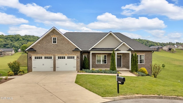 craftsman-style home with driveway, a front yard, and brick siding