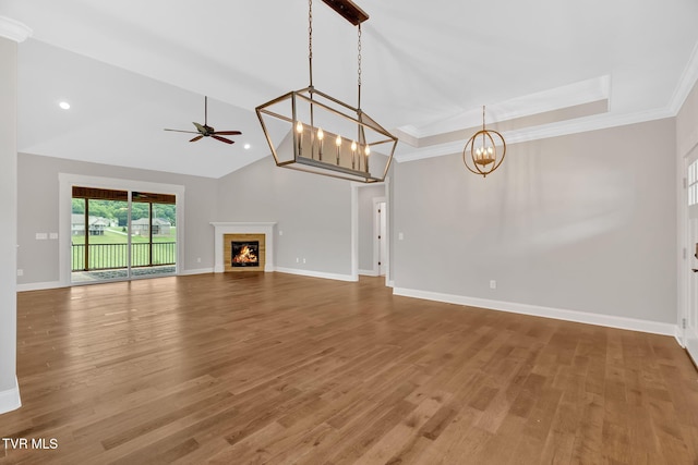 unfurnished living room with a chandelier, wood finished floors, a ceiling fan, crown molding, and baseboards
