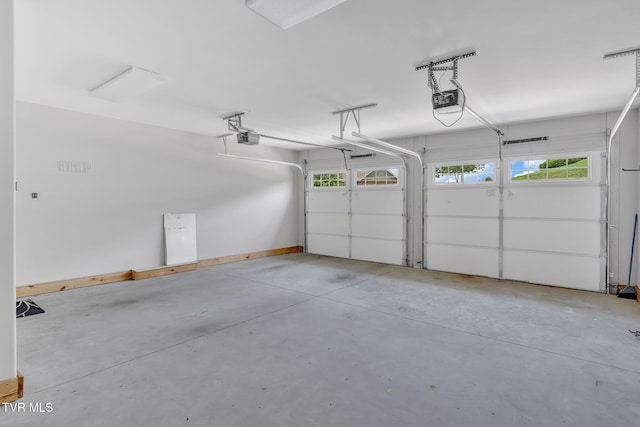 garage with a garage door opener and baseboards