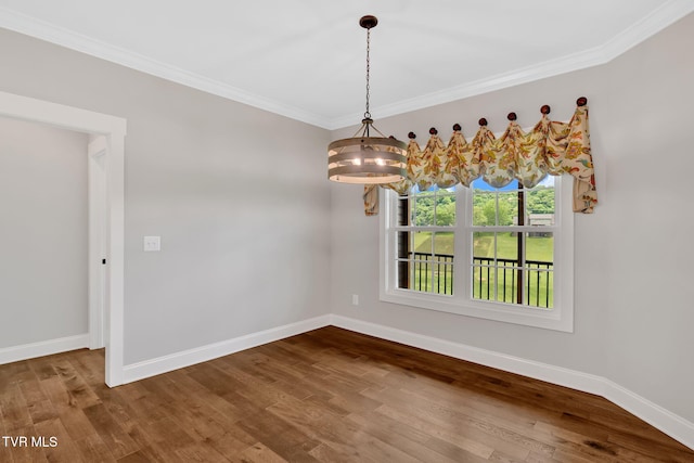 unfurnished dining area featuring baseboards, crown molding, dark wood-type flooring, and a chandelier