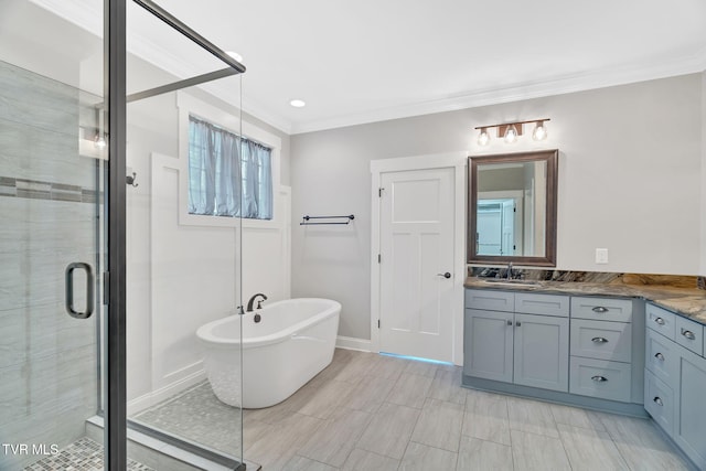 full bath featuring a stall shower, vanity, ornamental molding, a soaking tub, and baseboards
