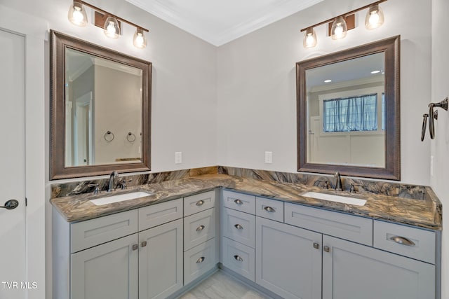full bath with double vanity, ornamental molding, and marble finish floors