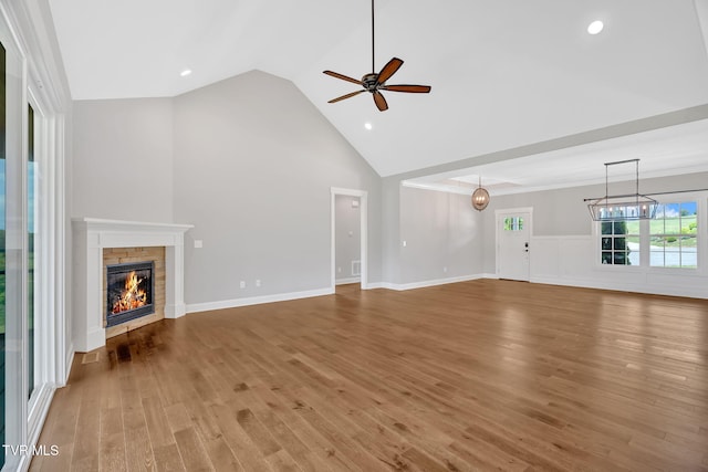 unfurnished living room with ceiling fan, a fireplace, wood finished floors, recessed lighting, and high vaulted ceiling