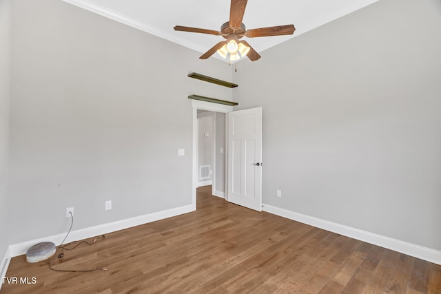unfurnished room featuring a ceiling fan, baseboards, wood finished floors, and crown molding
