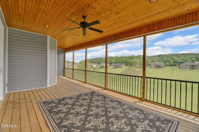unfurnished sunroom featuring a ceiling fan and plenty of natural light