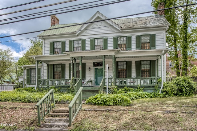 view of front of property featuring a chimney and a porch