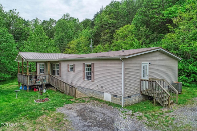 596 Devils Nose Rd, Rogersville, TN 37857 - back of house with metal roof, crawl space, central air condition unit, a lawn, and a wooded view