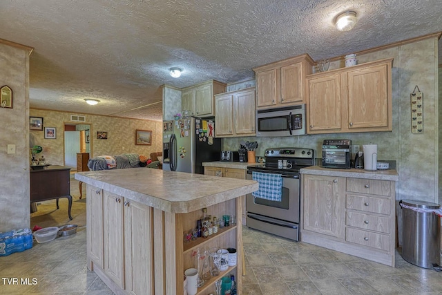 596 Devils Nose Rd, Rogersville, TN 37857 - kitchen featuring stainless steel appliances, light countertops, a textured ceiling, a kitchen island, and light brown cabinets