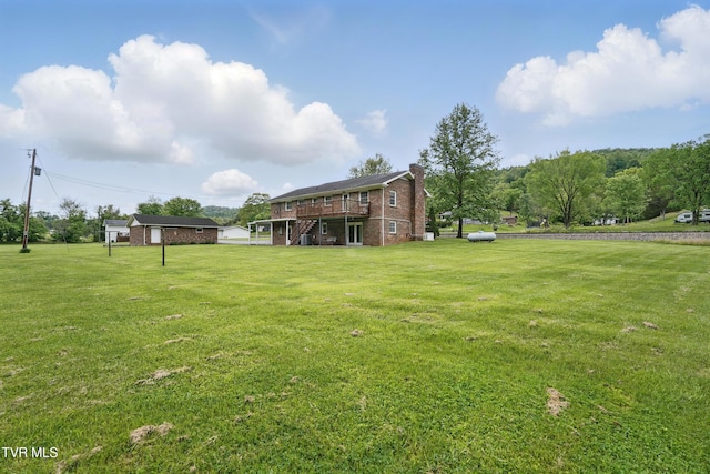 view of grassy yard featuring a wooden deck and stairs