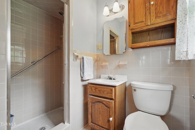 bathroom with a shower stall, toilet, tile walls, and vanity