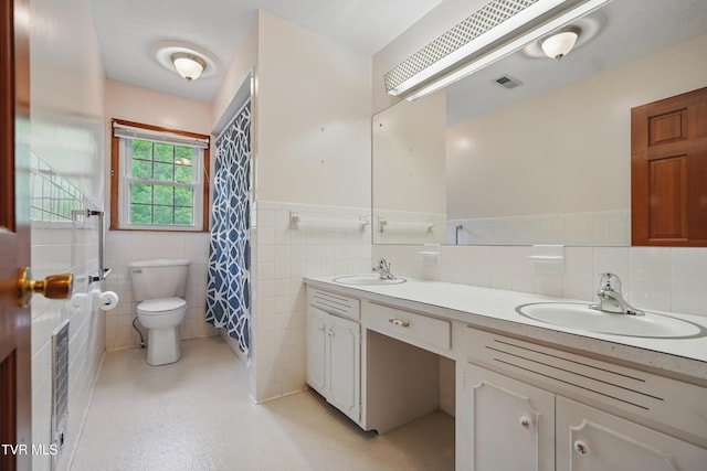 bathroom featuring a wainscoted wall, toilet, tile walls, double vanity, and a shower with shower curtain