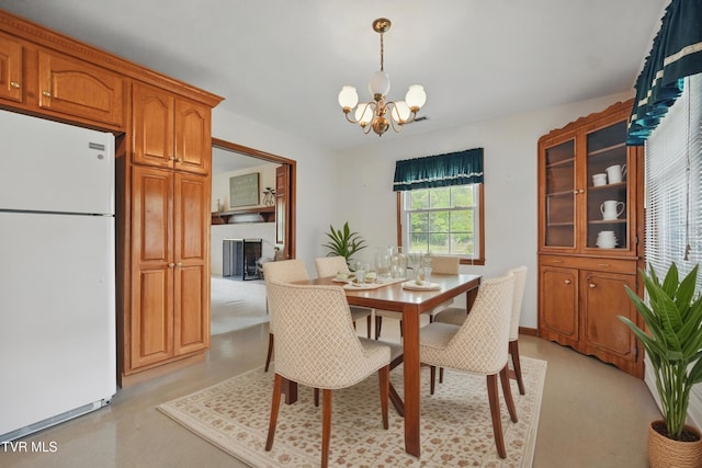 dining room with a chandelier and a fireplace