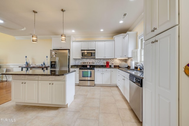 kitchen with stainless steel appliances, a sink, ornamental molding, a center island, and tasteful backsplash