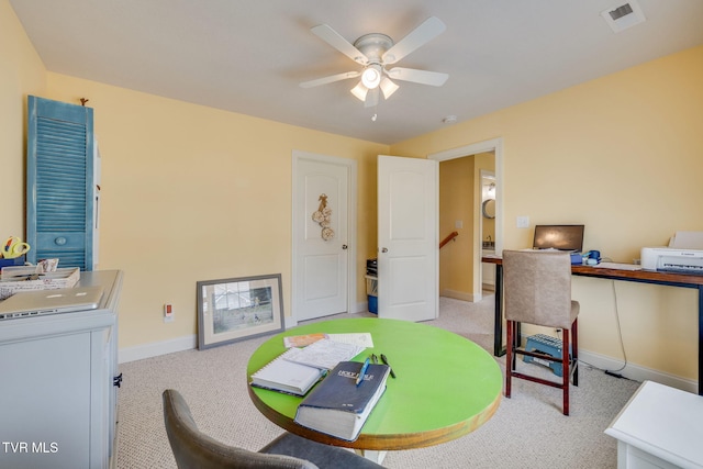 home office with a ceiling fan, light carpet, and baseboards