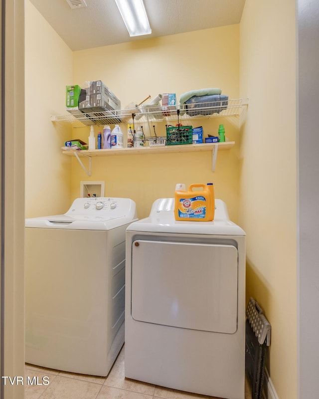 laundry area with washer and clothes dryer and tile patterned floors