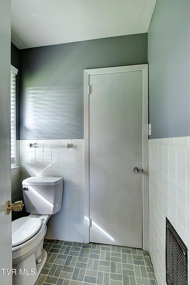416 Ridgefields Rd, Kingsport, TN 37660 - bathroom with tile walls, toilet, and a wainscoted wall