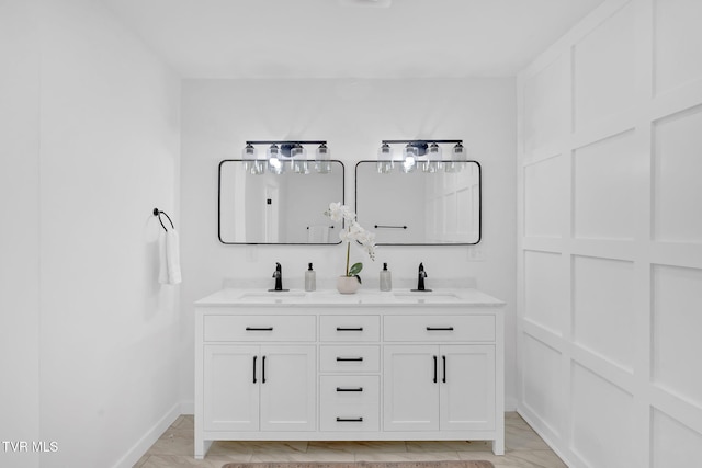 bathroom with double vanity and baseboards