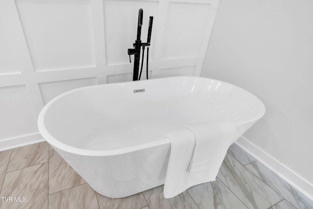 bathroom view of a soaking tub and baseboards