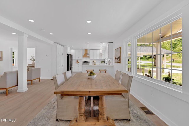 dining space featuring light wood finished floors, recessed lighting, and baseboards
