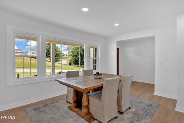 dining room featuring baseboards, light wood-style floors, and recessed lighting