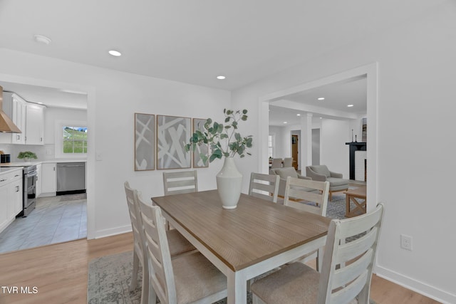 dining space featuring light wood-style floors, recessed lighting, and baseboards