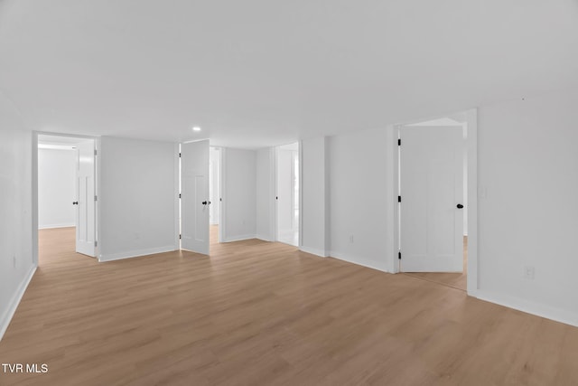spare room with light wood-style floors and baseboards