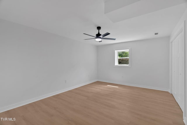 empty room with light wood-style floors, baseboards, and ceiling fan