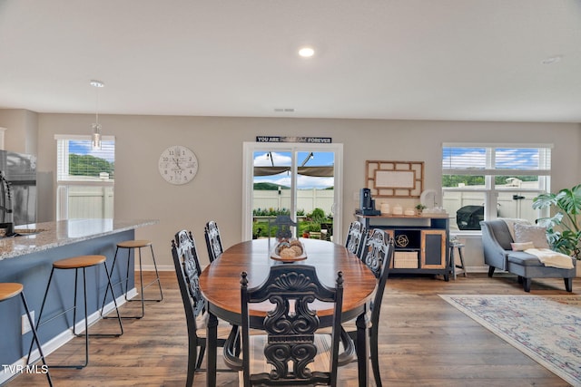 dining space featuring wood finished floors, recessed lighting, and baseboards