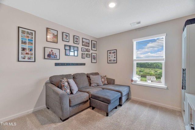 carpeted living room featuring baseboards