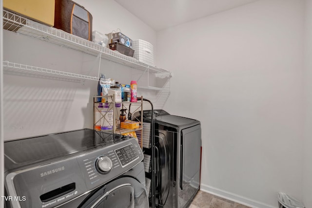 clothes washing area featuring washer and dryer and baseboards
