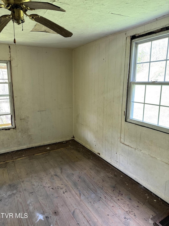 11590 Cedar Rd, Pound, VA 24279 - spare room featuring hardwood / wood-style flooring, ceiling fan, healthy amount of natural light, and wood walls