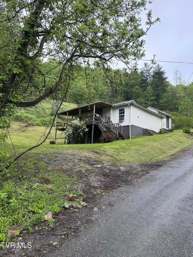 11590 Cedar Rd, Pound, VA 24279 - view of front of home featuring stairs, a forest view, and a front lawn