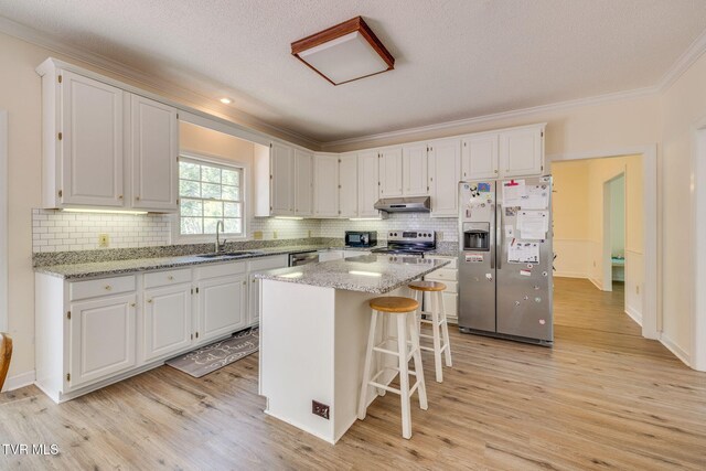 3502 Bondwood Cir, Johnson City, TN 37604 - kitchen featuring appliances with stainless steel finishes, under cabinet range hood, a sink, ornamental molding, and white cabinetry