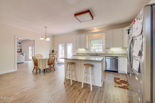 3502 Bondwood Cir, Johnson City, TN 37604 - kitchen featuring stainless steel appliances, a sink, a textured ceiling, a kitchen island, and white cabinets