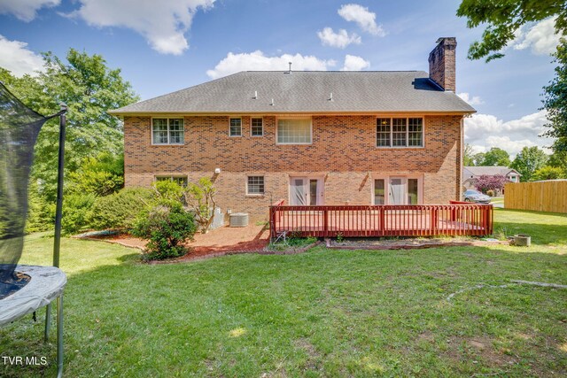 3502 Bondwood Cir, Johnson City, TN 37604 - rear view of house featuring a trampoline, a wooden deck, a chimney, and brick siding