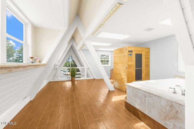 bedroom featuring a skylight and wood finished floors