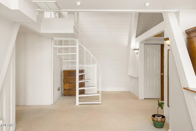 stairs featuring carpet flooring and wooden walls