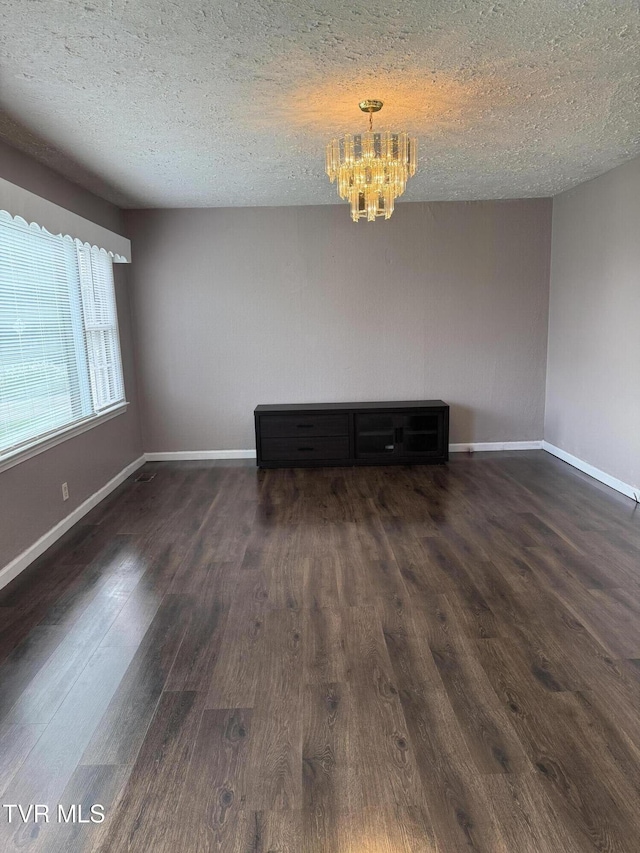 379 SW Oakland St, Abingdon, VA 24210 - unfurnished living room with a chandelier, dark wood finished floors, baseboards, and a textured ceiling