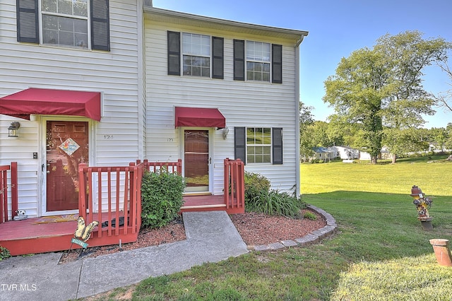 townhome / multi-family property with a front yard