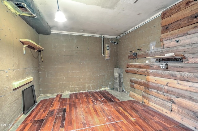 below grade area with hardwood / wood-style flooring and concrete block wall