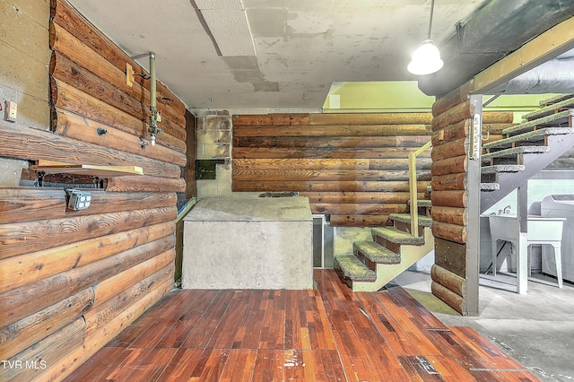corridor featuring stairway, log walls, and wood finished floors
