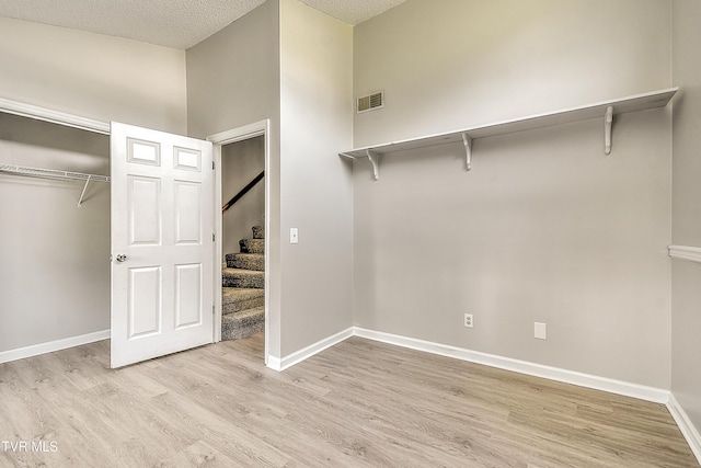 walk in closet with light wood-style floors