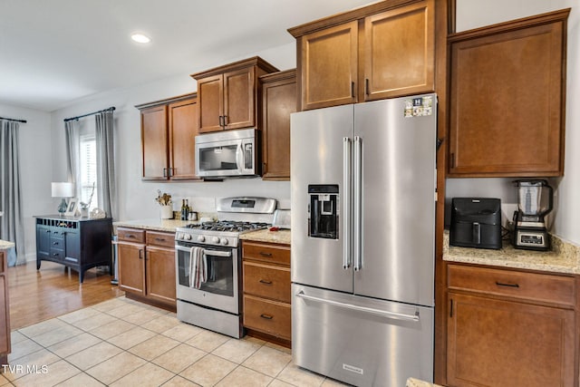 134 Chancery Ct, Piney Flats, TN 37686 - kitchen featuring stainless steel appliances, brown cabinets, light stone counters, recessed lighting, and light tile patterned floors